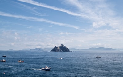 The blue sky white and blue boat on the surface of the sea during the day
